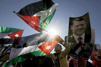 King Abdullah poster amidst Jordan flags
